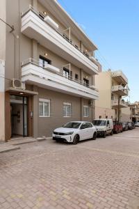 a white car parked in front of a building at Chania Experience Residence in Chania