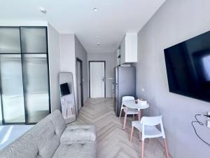 a living room with a couch and a table at Title Ledgendary 7th Floor in Bang Tao Beach +3 photos