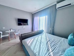a bedroom with a bed and a table and a dining room at Title Ledgendary 7th Floor in Bang Tao Beach