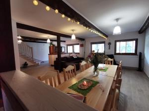 a dining room and living room with a table and chairs at Zielone Wzgórze in Lasowka