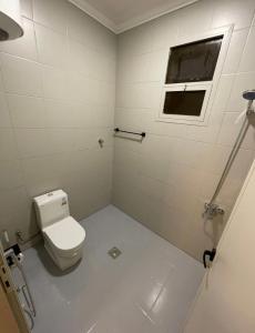 ein weißes Bad mit einem WC und einem Fenster in der Unterkunft استديو هادئ بدخول ذكي in Ar Rass