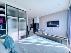a bedroom with a bed and a tv on the wall at Title Ledgendary 7th Floor in Bang Tao Beach