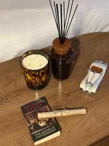 ein Tisch mit einer Kerze, einem Buch und einer Zigarette in der Unterkunft استديو هادئ بدخول ذكي in Ar Rass + 1 Foto