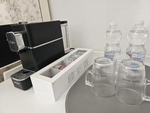 a table with a bottle of water and two glass containers at Royal Suites Venice in Venice