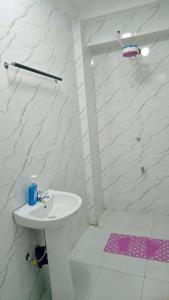 Un baño blanco con lavabo y ducha en Exciting, en Ongata Rongai 