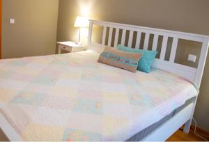 a bed with a quilt and a pillow on it at Meio Mundo in Várzea