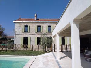 a large stone house with a pool in front of it at la caquetoire in Les Églisottes-et-Chalaures