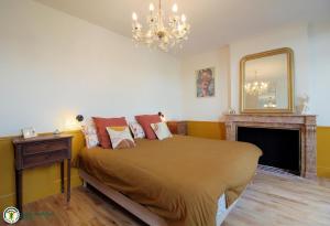 a bedroom with a bed with a fireplace and a chandelier at la caquetoire in Les Églisottes-et-Chalaures