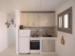 a kitchen with a white refrigerator and a sink at Moniasma Rustic Stone House in Folegandros in Ano Meria +21 photos