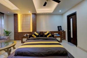 Un dormitorio con una cama grande y una mesa. en The Grand Rustam Villa, en Gurgaon
