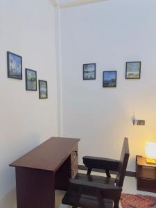 a desk and a chair in a room with pictures on the wall at Moonlit serenity Tangalle in Tangalle