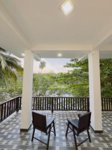 two chairs on a porch with a view of the water at Moonlit serenity Tangalle in Tangalle