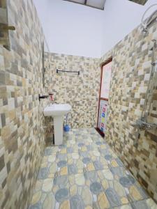 a bathroom with a sink and a tiled wall at Moonlit serenity Tangalle in Tangalle