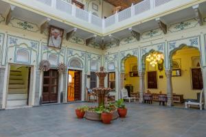 ein großes Gebäude mit Blumen im Innenhof in der Unterkunft Jeevan Haveli Heritage Hotel & Museum in Nawalgarh