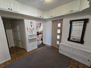 a kitchen with white cabinets and a window and a mirror at Centrum Jagoda in Pisz