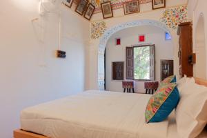 ein Schlafzimmer mit einem großen Bett und einem Fenster in der Unterkunft Jeevan Haveli Heritage Hotel & Museum in Nawalgarh