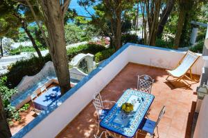 a patio with a table and chairs and a tree at Casa Schiattarella Capri in Capri