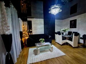 a living room with a chandelier and a table and chairs at Apartament Marzenie in Siechnice