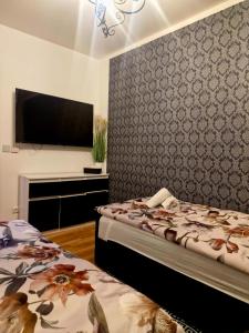 a bedroom with two beds and a flat screen tv at Apartament Marzenie in Siechnice +27 photos