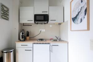 レオーベンにあるApartment at Main Square - 35 m2 - Netflix - Quietの白いキャビネットと壁掛けテレビ付きのキッチン +15枚の写真