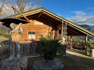 派尔巴赫Ferienwohnung Holzer的一座小木屋前矗立着一尊手持棒球棒的男子雕像。
