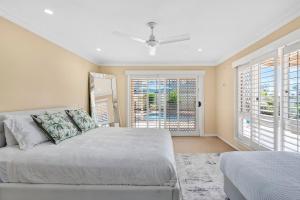 een slaapkamer met een bed en een groot raam bij Waterfront entertainers dream with private beach in Gold Coast +18 foto's