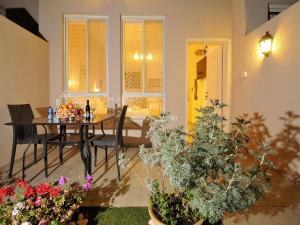 a dining room with a table and chairs and flowers at Zimmer BaSadot in Yavneʼel