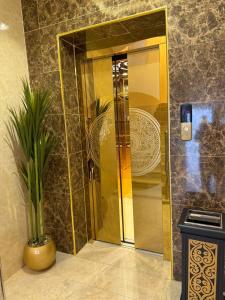 ein Badezimmer mit Dusche, Spiegel und einer Pflanze in der Unterkunft شقق نطوان المفروشة in Abha