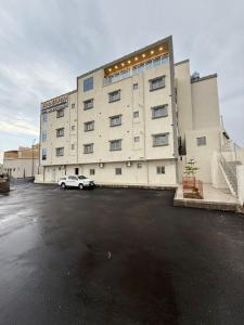 a large building with a car parked in a parking lot at شقق نطوان المفروشة in Abha