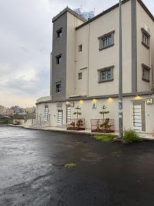ein großes weißes Gebäude mit Bäumen davor in der Unterkunft شقق نطوان المفروشة in Abha + 4 Fotos