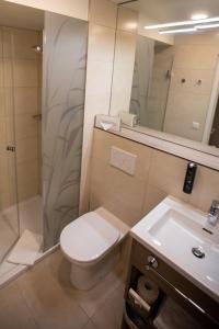 リンツにあるStadtoase Kolping Hotelのトイレ、シャワー、洗面台を備えたバスルーム