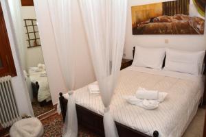 Un dormitorio con una cama con cortinas blancas. en ΑΡΣΙΝΟΗ apartments1, en Arachova