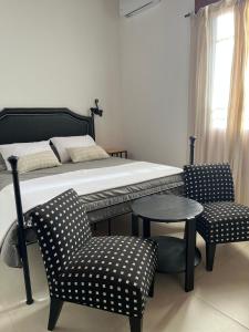 een slaapkamer met een bed, een tafel en stoelen bij Farrell Suite Casco Historico in San Antonio de Areco