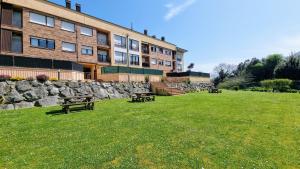 un edificio con panchine nell'erba di fronte a un edificio di Apartamento Luz de Poniente a Llanes