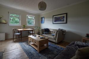 a living room with a couch and a table at Loch Lomond Apartment in Alexandria
