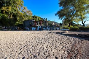 a sandy beach with a building in the background at Residenz La Selva Studio-Apartments in Ghiffa