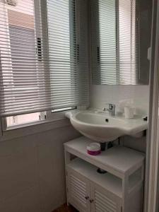 a bathroom with a sink and a mirror and a window at Singular piso junto al puerto - Arostegi Etxea in Bermeo