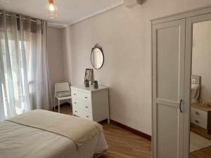 a bedroom with a bed and a mirror and a dresser at Singular piso junto al puerto - Arostegi Etxea in Bermeo