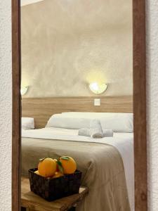 厄尔·阿尔特HS Altet Suites - Alicante Airport的卧室里有一张床，篮子里放着橘子。