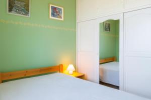 una camera da letto con un grande letto bianco e una lampada di Gîte le Platane a Montagnac Altre 25 foto