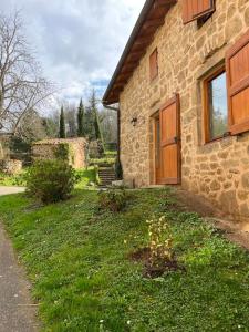 una casa de piedra con una puerta de madera y un patio en Clos du Régrillon, en Pélussin