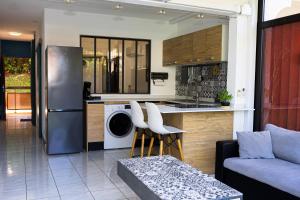 a kitchen and living room with a washer and dryer at Cocon Madeleine Confort et piscine wifi et climatisation in Cayenne
