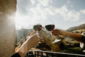 two people holding up glasses of red wine at Schlosshotel Stecklenberg in Thale