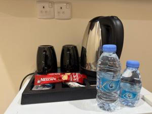 a counter with two bottles of water and a blender at Sanabel ALmshaan Hotel in Al Wudayy