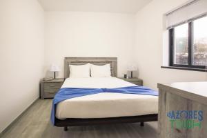 a bedroom with a large bed and two windows at Silver Gate Home in Cinco Ribeiras