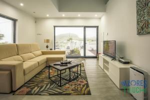 a living room with a couch and a tv at Silver Gate Home in Cinco Ribeiras