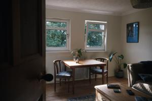 a living room with a table and two windows at Loch Lomond Apartment in Alexandria