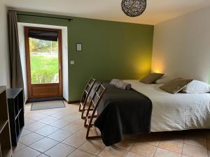 1 dormitorio con 1 cama con paredes verdes y puerta en Clos du Régrillon, en Pélussin