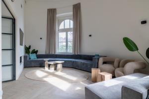 a living room with a blue couch and a table at Watertoren Vlissingen in Vlissingen