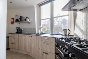 a kitchen with a stove and a window at Watertoren Vlissingen in Vlissingen
